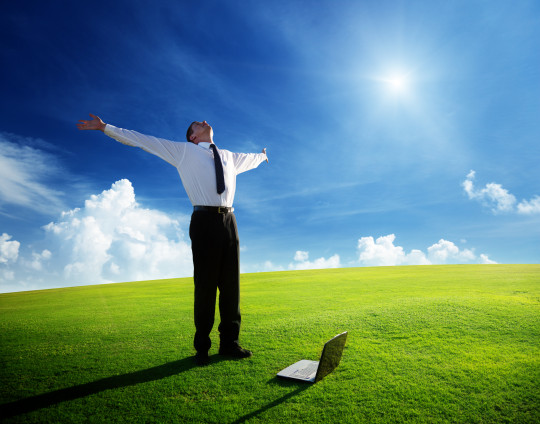 Happy young businessman on spring field