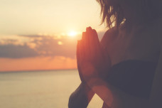 Young woman practicing yoga on the beach.